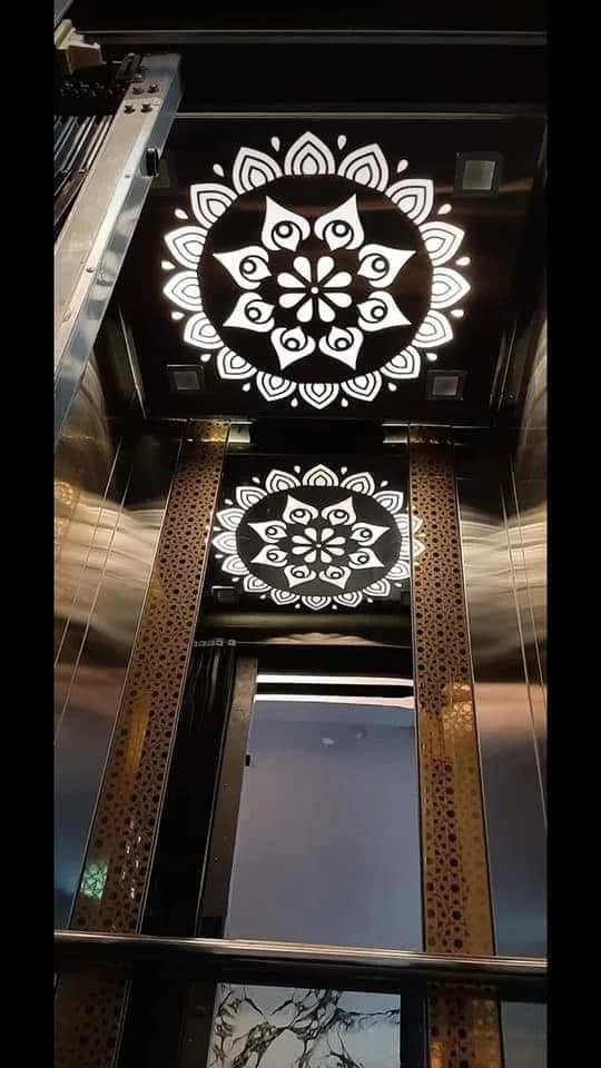 Elevator interior with a backlit mandala pattern on the ceiling and walls
